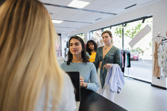 Customers at checkout counter in fashion store