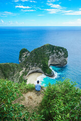 Man traveler at viewpoint at Kelingking Beach in Nusa Penida island, Bali, Indonesia. summer background and summer vacation concept. © Balnyes Visuals