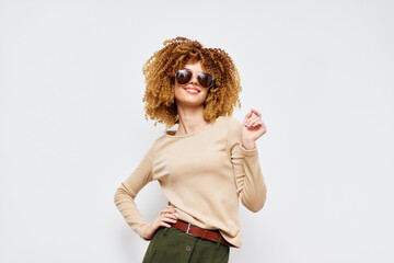 Fashion model showcasing stylish sunglasses against a clean white background, wearing a beige top and green pants, exuding confidence and trendiness Perfect for lifestyle and fashion themes