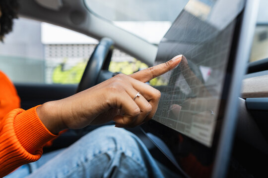 Finger of woman touching screen of navigation system