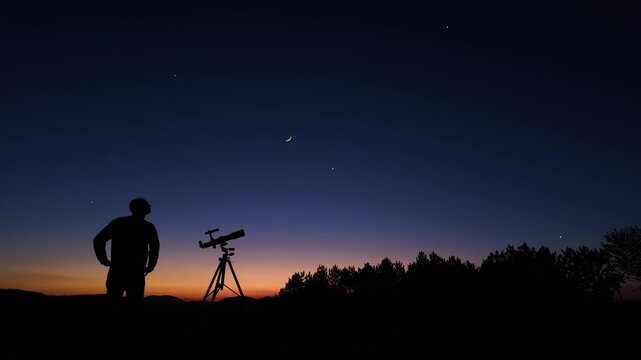 Amateur astronomer looking at the evening skies, observing planets, stars, Moon and other celestial objects with a telescope.	
