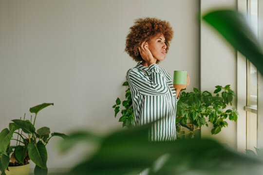 Thoughtful businesswoman with hand in hair standing at office