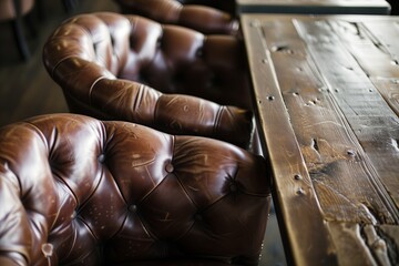 Obraz premium A rustic wooden table paired with luxurious leather armchairs creates a warm and inviting atmosphere.