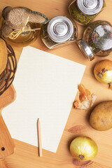 Paper, pencil, jug of olive oil, potatoes, onion, cutting board and spices