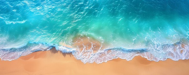 Aerial view of a serene beach with turquoise water gently lapping against the sandy shore, perfect for relaxation and vacation.
