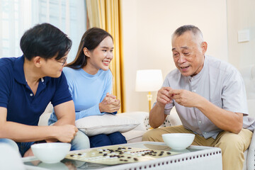 Son and daughter enjoy playing Go Board Game with their father in free time weekend.