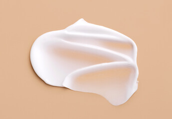 creamy smear of white cosmetic texture on beige background skin care concept