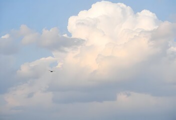 Clear blue sky with a single, fluffy white cloud drifting across it