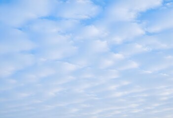 Fototapeta premium Clear blue sky with fluffy white clouds drifting slowly