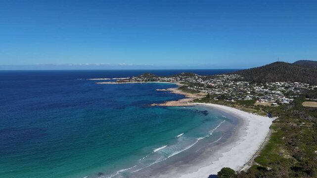 Wide panoramic view of the white sandy beach and the town of Bicheno in Tasmania, Australia.