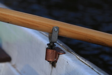 A close-up shot of a wooden rail on a boat, suitable for use in nautical-themed designs or as a decorative element.