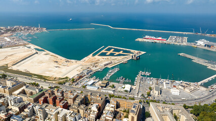Aerial view of the main port in Bari, Puglia, Italy. There are ferries and large industrial ships docked or departing.