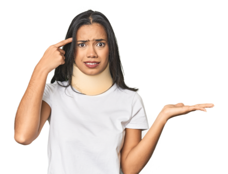 Latina with neck brace in studio holding and showing a product on hand.