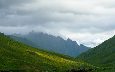 landscape with clouds and mountains, meadow in the Kashmir valley