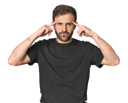 Studio portrait of young Hispanic male focused on a task, keeping forefingers pointing head.