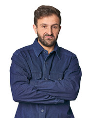 Studio portrait of young Hispanic male suspicious, uncertain, examining you.