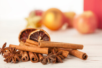 Cinnamon quills, star anise and dried orange slices, christmas decoration in background