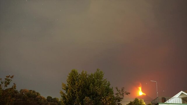 Time lapse del cielo stellato sul vulcano Etna in eruzione, con colonna di cenere e fulmini,  Sicilia