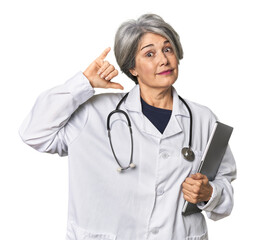 Caucasian mid-age doctor holding laptop showing a dislike gesture, thumbs down. Disagreement concept.