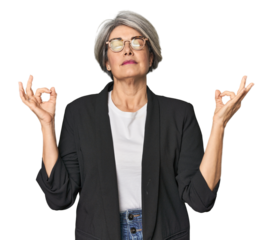 Caucasian mid-age female in business suit relaxes after hard working day, she is performing yoga.