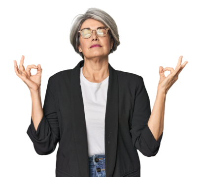 Caucasian mid-age female in business suit relaxes after hard working day, she is performing yoga.