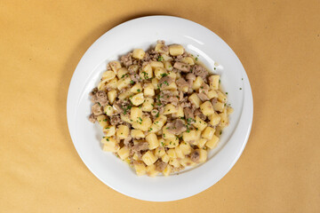 Gnocchi with porcini mushrooms.
Typical Italian homemade dish, gnocchi with porcini mushrooms on a rustic yellow paper tablecloth