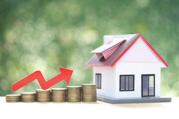 Mortgage,Model house and stack of coins money on natural green background,Business investment and real estate concept