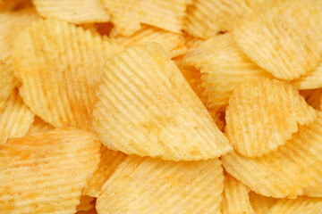 Crispy potato chips rotating in macro. Golden fried potatoes close up. Potato snack for unhealthy fast food.	
