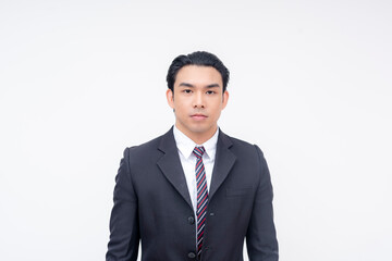 Portrait of a stoic and serious young asian businessman in a suit and tie, standing relaxed. Isolated on a white background.