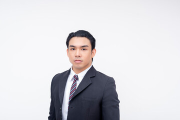Portrait of a stoic and serious young asian businessman in a suit and tie, standing relaxed....