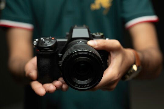 Men holding Nikon Z6 III camera in hand. selective focus