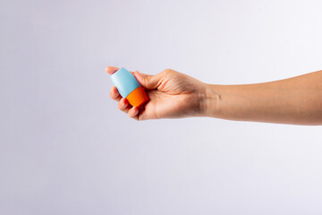 Blue cosmetic bottle, Skin care or sunscreen cosmetic in hand on white background.