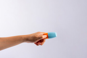 Blue cosmetic bottle, Skin care or sunscreen cosmetic in hand on white background.