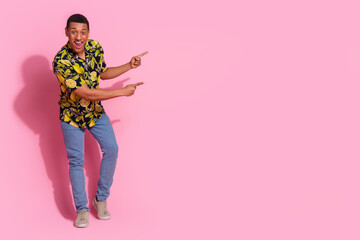 Full length photo of handsome young guy point excited empty space dressed stylish tropical print garment isolated on pink color background