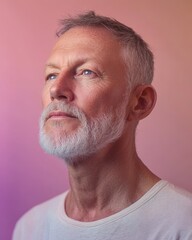 Obraz premium Portrait of a thoughtful mature man with gray beard against pastel background
