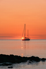 Silhouette Of A Pleasure Boat Moored In The Harbor Of The Coastal And Touristic Village Of Collioure (Cotlliure). France During A Beautiful Sunrise On The Waters Of The Mediterranean Sea. Orange Sky.