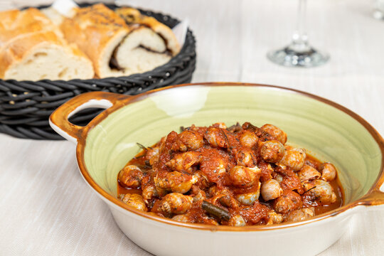 Bolinus brandaris or murici, Plate of seafood morsels with tomato sauce, boiled sea snails, Mediterranean Food in an elegant gourmet restaurant dish.