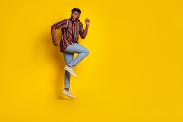 Full body portrait of nice young man jump look empty space wear shirt isolated on yellow color background