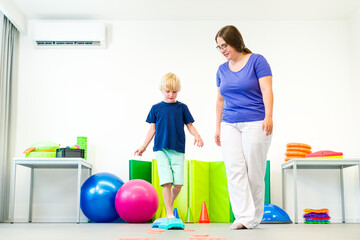 Obraz premium Kids physio therapy. Child and physical therapist exercising during session. Bilateral coordination is the ability to use both sides of the body together in a coordinated way.