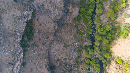 Obraz premium Aerial photography of the landscape. Background and texture of mountain layers, clay, cracks, sedimentary rock and scorched forest with green spruce trees on cliff. Drone, aerial view