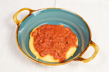Polenta dish with fish.
Typical traditional Italian dish, polenta with fish sauce, calamari, shrimp and clams.