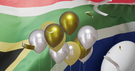 Image of confetti and balloons over white rugby ball and flag of south africa