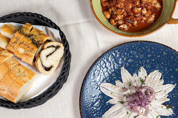 Marinated anchovies served in an elegant dish from a gourmet restaurant.
Pickled anchovies with garlic and parsley marinated in vinegar in a round blue plate