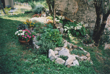 Mountain Garden Full of Flowers in Front of an Ancient Stone Hut in Valli del Natisone, Italy-Slovenia Border, During Summer. Clabuzzaro, Udine Province, Friuli Venezia Giulia, Italy. Film Photography