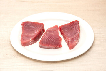 Dressed fresh tuna steak steaks on a white plate. raw tuna steak