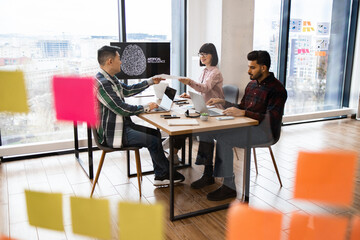 Group of professionals collaborating in modern office setting with presentation on artificial intelligence displayed. Team discussion and brainstorming ideas shown with city view
