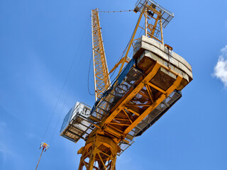 Naklejka premium A large yellow crane stands out against a bright blue sky