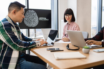 Group of IT experts developing artificial intelligence in modern office setting. Collaborative work...