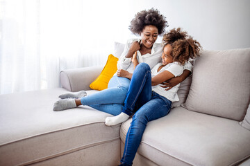 Happy Mother and Daughter Relaxing on Cozy Sofa Together