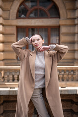 Fototapeta premium Young beautiful woman wearing coat walking in the city centre of Prague, Europe